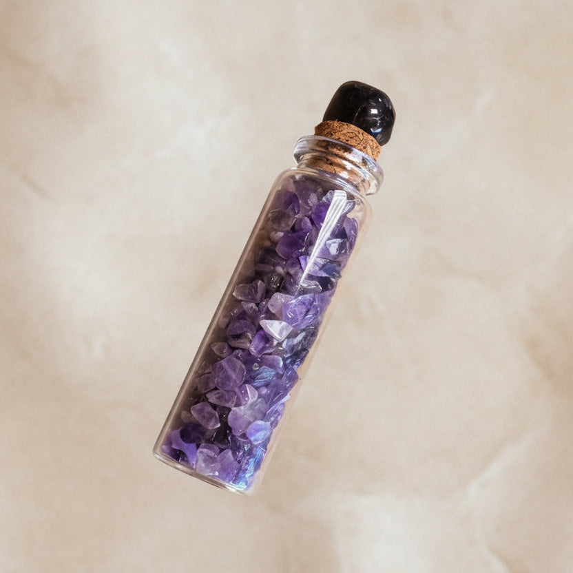 Vial filled with purple crystals on a beige background