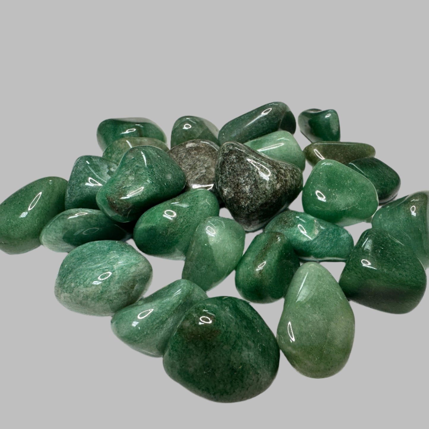 Green aventurine tumbled stone - hand holding crystal showing size and polished surface
