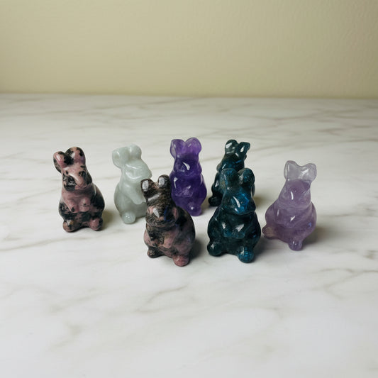 Set of colorful crystal animal figurines on a neutral surface