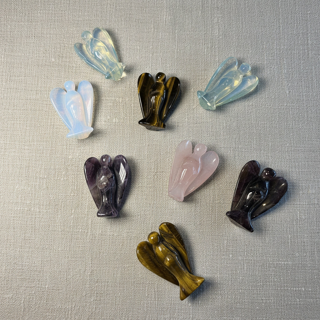 Set of colorful gemstone angel-shaped objects on a white surface
