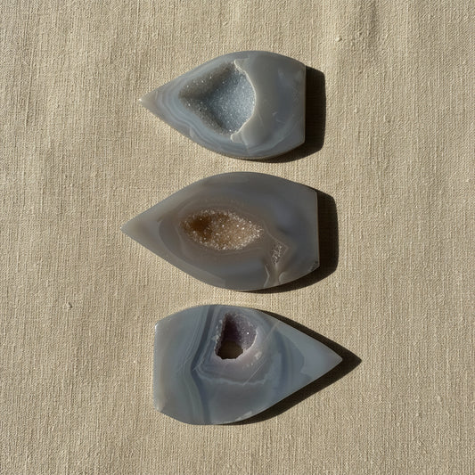 Three teardrop-shaped agate stones on a white surface
