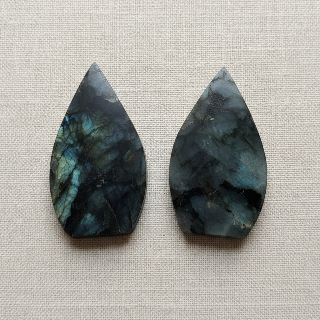 two flame shaped gemstones on white surface