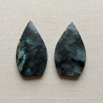 two flame shaped gemstones on white surface