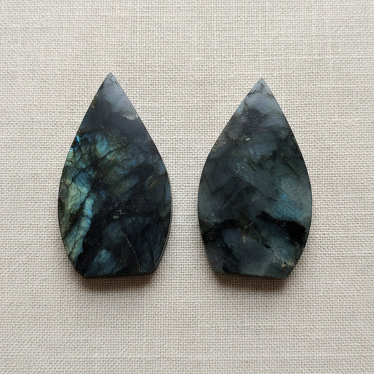 two flame shaped gemstones on white surface