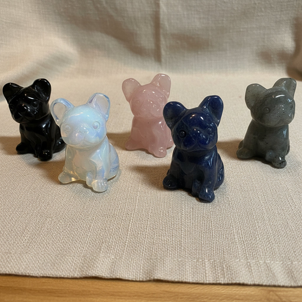 Five crystal animal French Bulldog figures on a tan surface