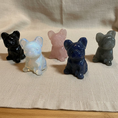 Five crystal animal French Bulldog figures on a tan surface