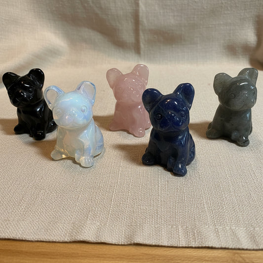 Five crystal animal French Bulldog figures on a tan surface
