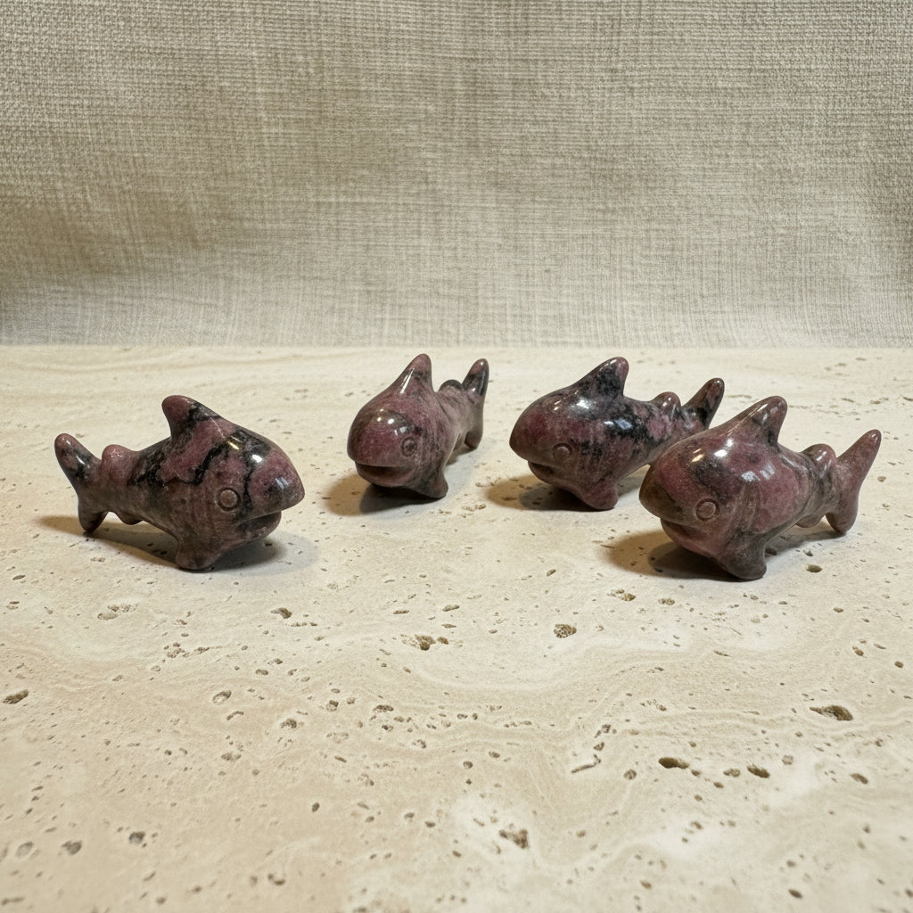 Five small shark figurines on a white surface