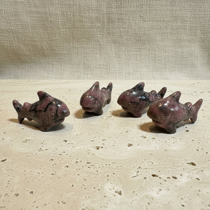 Five small shark figurines on a white surface
