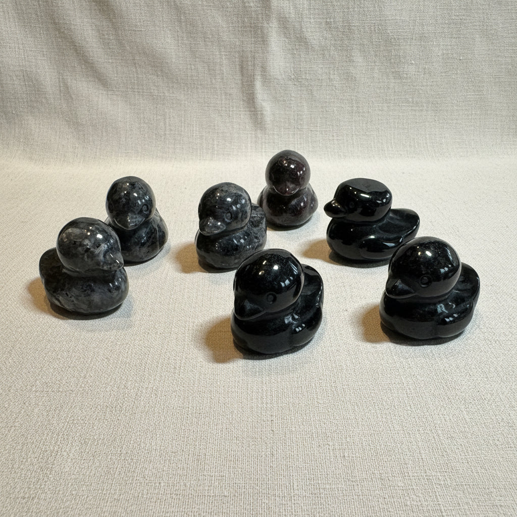Set of black stone ducks on a white background