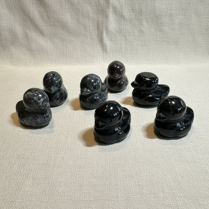 Set of black stone ducks on a white background