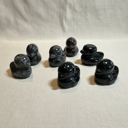 Set of black stone ducks on a white background